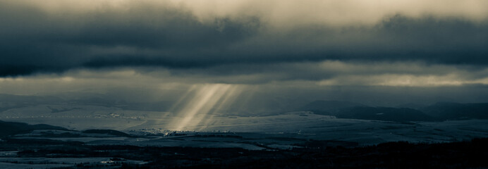 Mountains view, sun rays goues from the cloudy ski.