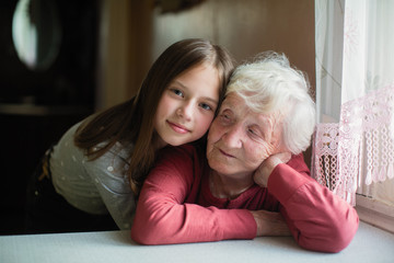 Obraz na płótnie Canvas Little cute girl and her old grandmother portrait.