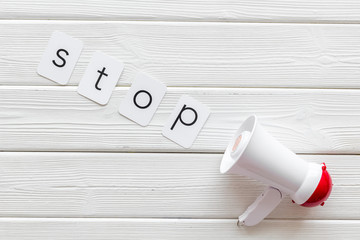 Stop announcement symbol with megaphone and text on white wooden background top view