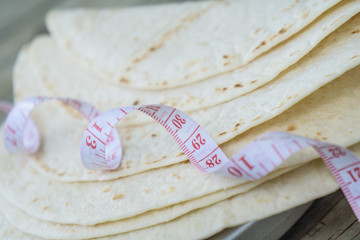 Close up of measuring tape on low carb tortillas or naan bread.