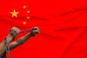 muscular male hands wrapped in a thick iron czar against the background of the state flag, the...