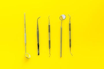 stomatologist instruments on yellow doctor's office desk background top view