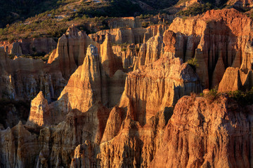 Earth Forest of Yuanmou in Yunnan Province, China - Exotic earth and sandstone formations glowing in the sunlight. Naturally formed pillars of rock and clay with unique erosion patterns. China Travel