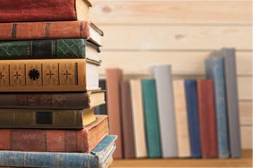 Ancient books in a row on wooden background