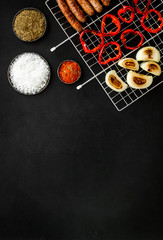 barbecue, sausages, vegetables on black background top view mockup