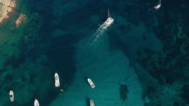 View from above, stunning aerial view of a beautiful bay full of boats and luxury yachts. A turquoise sea bathes the green and rocky coasts. Liscia Ruja, Emerald Coast  Sardinia, Italy