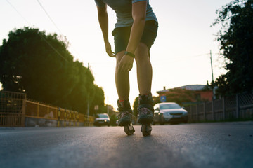 Close up on rollerblade roller blade skates man legs against sun in the summer evening riding on...