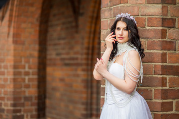 Closeup Portrait of Romantic Sensual Caucasian Bride With Crown And Necklace Posing Against Old Brick Wall Outdoos.
