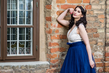 Sexy Sensual Young Brunette Lady Posing in Tiara Against Old Brick Wall Outdoors