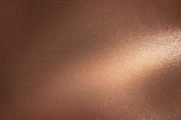 Glowing dark bronze metal wall with scratched surface, abstract texture background