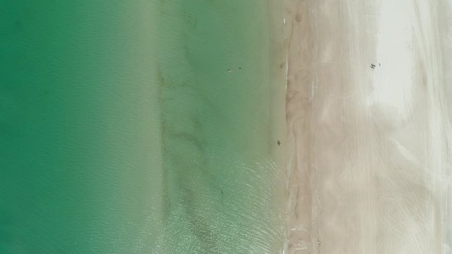 Calm ocean from top with people swimming