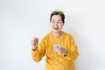 Senior asian woman listening to music with earphone,Elderly female using smartphone feeling funny and enjoying,Relaxing time,Happy and smiling