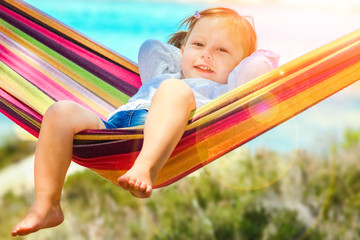 Fototapeta na wymiar happy child by the sea on hammock in greece background