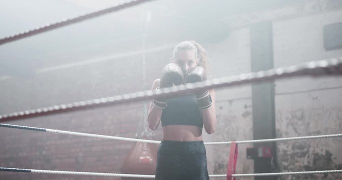 Young adult female boxer stepping into the ring