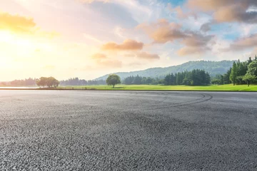 Zelfklevend Fotobehang Brede racebaan en groen bos natuurlandschap bij zonsondergang © ABCDstock