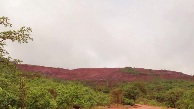 Time Lapse of moving clouds above the chopped off Mountian called Krauncha Giri Sandur where mining takes place regularly.