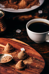Obraz na płótnie Canvas Homemade chocolate truffles coated in cocoa powder with black coffee