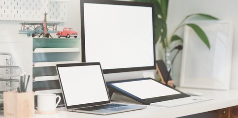 Fototapeta na wymiar Blank screen desktop computer and tablet in modern workplace