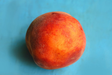 ripe peaches on a blue board.