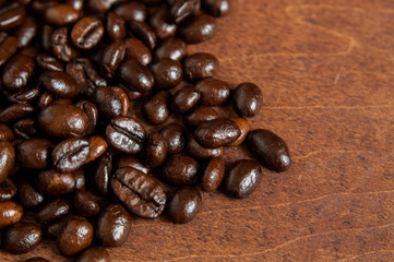 Freshly roasted scattered dark coffee beans, with mood filter, close up
