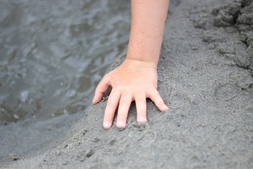 Young person playing on the sandy beach 