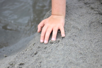 Young person playing on the sandy beach 