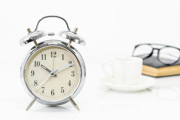 Fototapeta na wymiar Silver alarm clock with old books