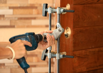 Drilling and installation of new lock on the wooden door