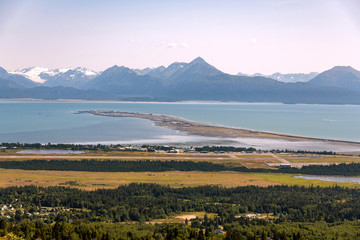 An elevated view of the Homer Spit and Kachemak Bay in Homer, Alaska during a summer day.