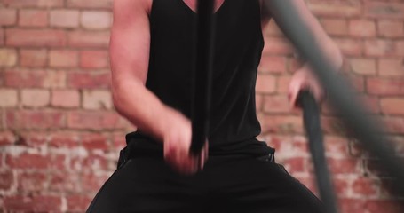 Closeup adult male working out with battle ropes