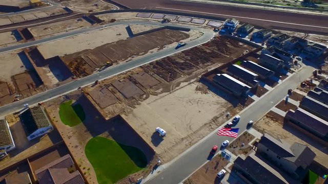 Aerial shot panning down to the US flag over a construction site in Arizona