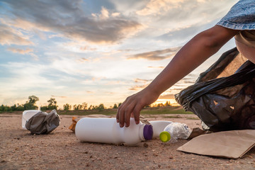 The volunteer picking up a bottle plastic , protect environment concept.