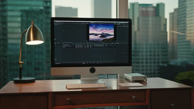 workplace with view on city, Downtown LA in background, big screen of computer, editing photos, work corner