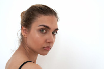 Naklejka premium Closeup portrait of a beautiful young blonde with green eyes, white background