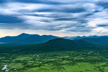 Panoramic view of the city Petropavlovsk-Kamchatsky and volcanoes: Koryaksky Volcano, Avacha Volcano, Kozelsky Volcano. Russian Far East, Kamchatka Peninsula.