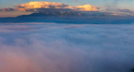 Fototapeta na wymiar Mountains emerging from a sea of clouds at sunrise-Tatra Mountains, Poland