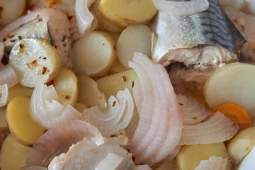 Stewed mackerel fish pieces with potatoes closeup