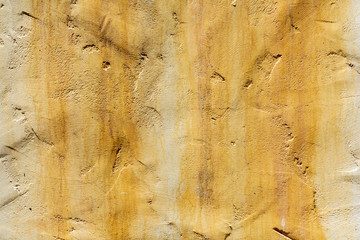 Painted wall with the wide water stain brush strokes in warm light yellow, peach color