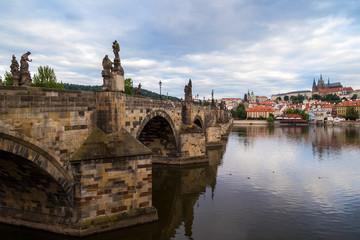 Fototapeta premium View of the empty Charles Bridge (Karluv most) over Vltava River, Mala Strana District (Lesser Town) and Prague (Hradcany) Castle in Prague, Czech Republic, on a cloudy day.