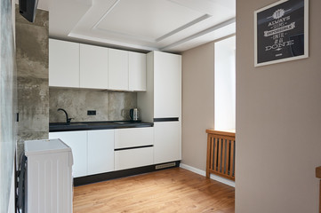 white minimalist kitchen with black countertop and sink