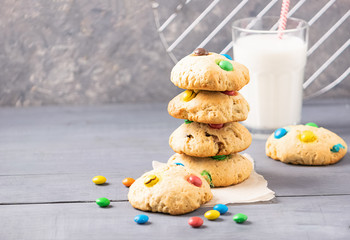Homemade cookies decorated with multi-colored sweets dragees in a stack on a gray table background. Copy space.