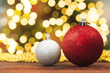Christmas balls on a wooden table against blurred shiny bokeh background