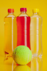 Plastic bottle full of drink on a bright yellow background