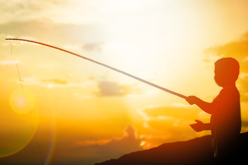 happy child fishing by the sea silhouette