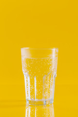 Glass of water on yellow background. Healthy lifestyle