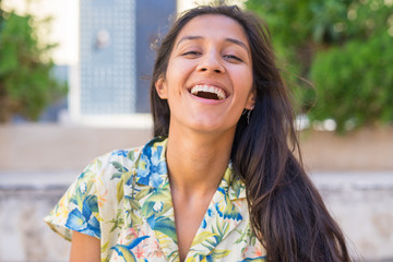 Young indian woman laughing in the street