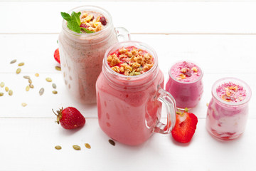 Strawberry with yogurt on white rustic wooden background. Cream dessert