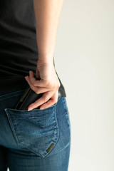 A woman bring out money wallet from jeans pocket on white background with copy space.