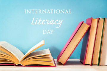 International Literacy Day concept with stack of books on a blue background.