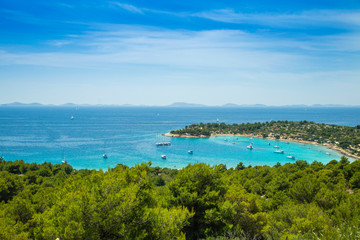 Fototapeta na wymiar Croatia, Adriatic coast, panoramic view on Kosirina beach lagoon on Murter island, anchored sailing boats and yachts on blue sea